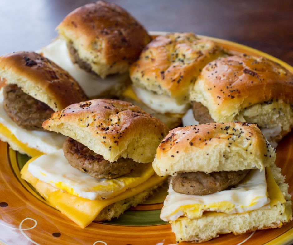 A plate of breakfast sandwiches with sausage eggs and cheese