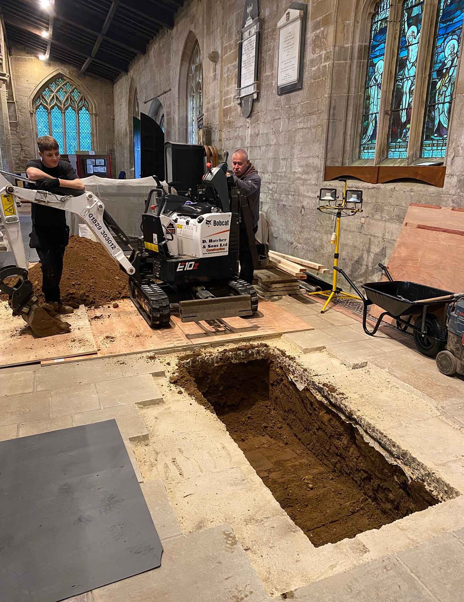 A DHS Plant Hire micro digger excavating a grave for Captain Mathew Flinders at St Mary & The Holy Rood church