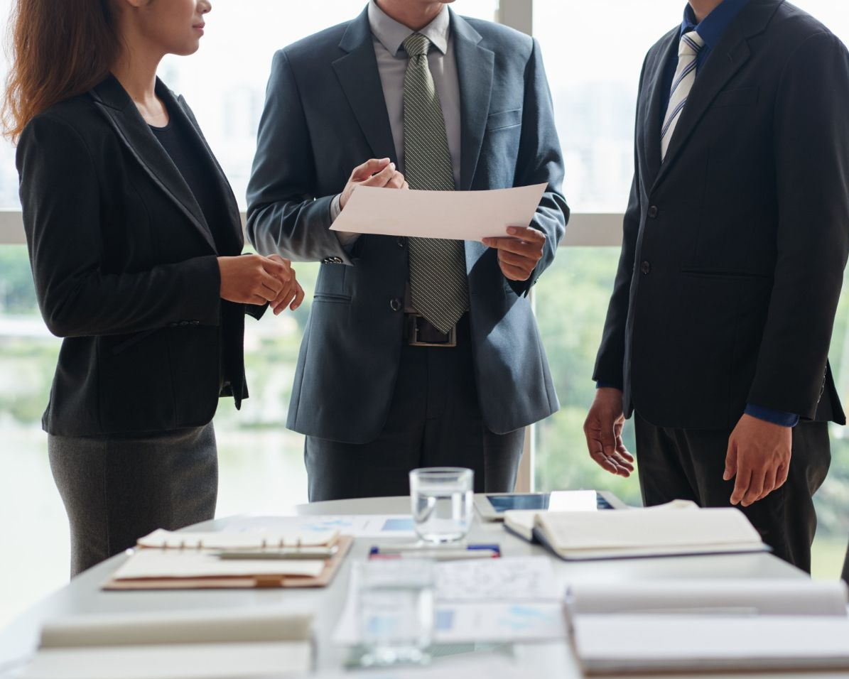 Three people reviewing documents at a table in an office. Trifecta: Charged with Domestic Assault, Order of Protection and Facing Divorce Law Attorney in Nashville, Tennessee