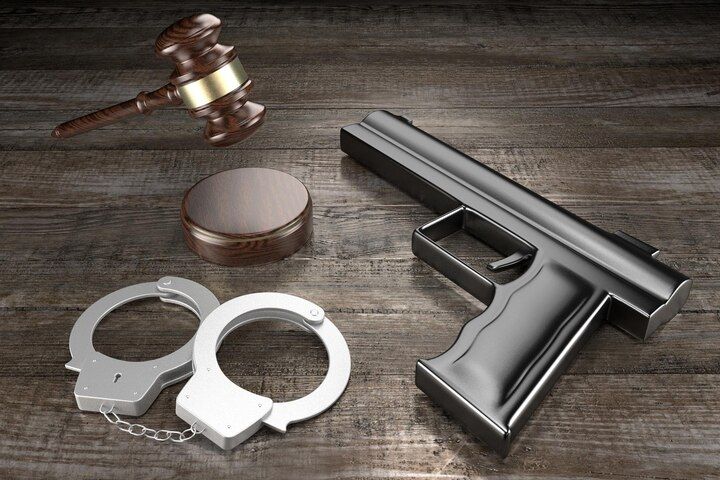 Gavel, sound block, handcuffs, and a handgun on a wooden surface. Firearm During Dangerous Felony Law Attorney in Nashville, Tennessee