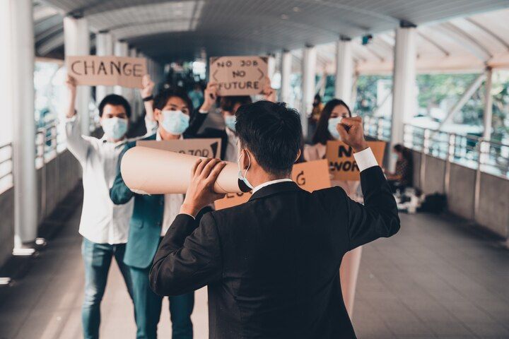 People protesting with signs, one using a megaphone in an urban setting. Public Order / Obstruction Law Attorney in Nashville, Tennessee