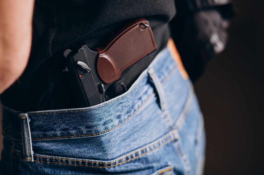 Gun in jeans pocket, brown handle visible, dark shirt. Unlawful Weapon Possession Law Attorney in Nashville, Tennessee