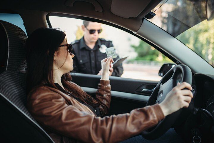 Woman in car receives a citation from a police officer. Driving on Suspended License Law Attorney in Nashville, Tennessee