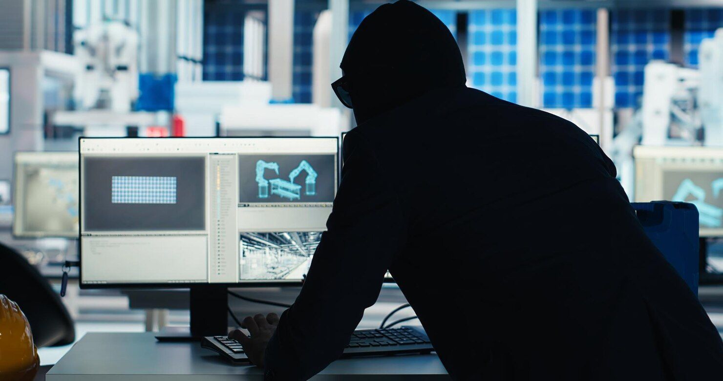 Person in a dark hoodie looking at a computer screen in a lab setting, likely controlling robotics. Theft of Services Law Attorney in Nashville, Tennessee