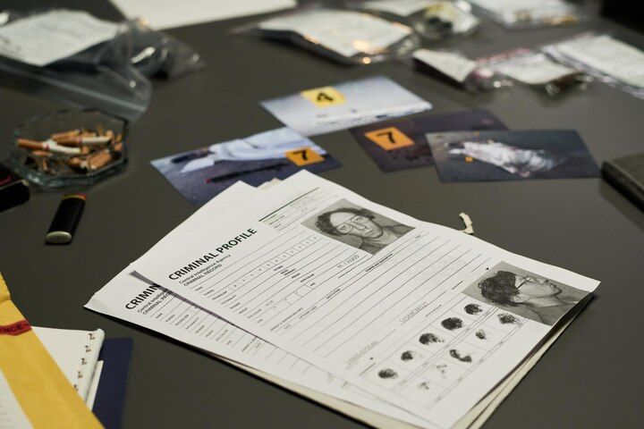 Crime scene investigation: criminal profile documents, photos, and evidence bags on a table. Second Degree Murder Law Attorney in Nashville, Tennessee