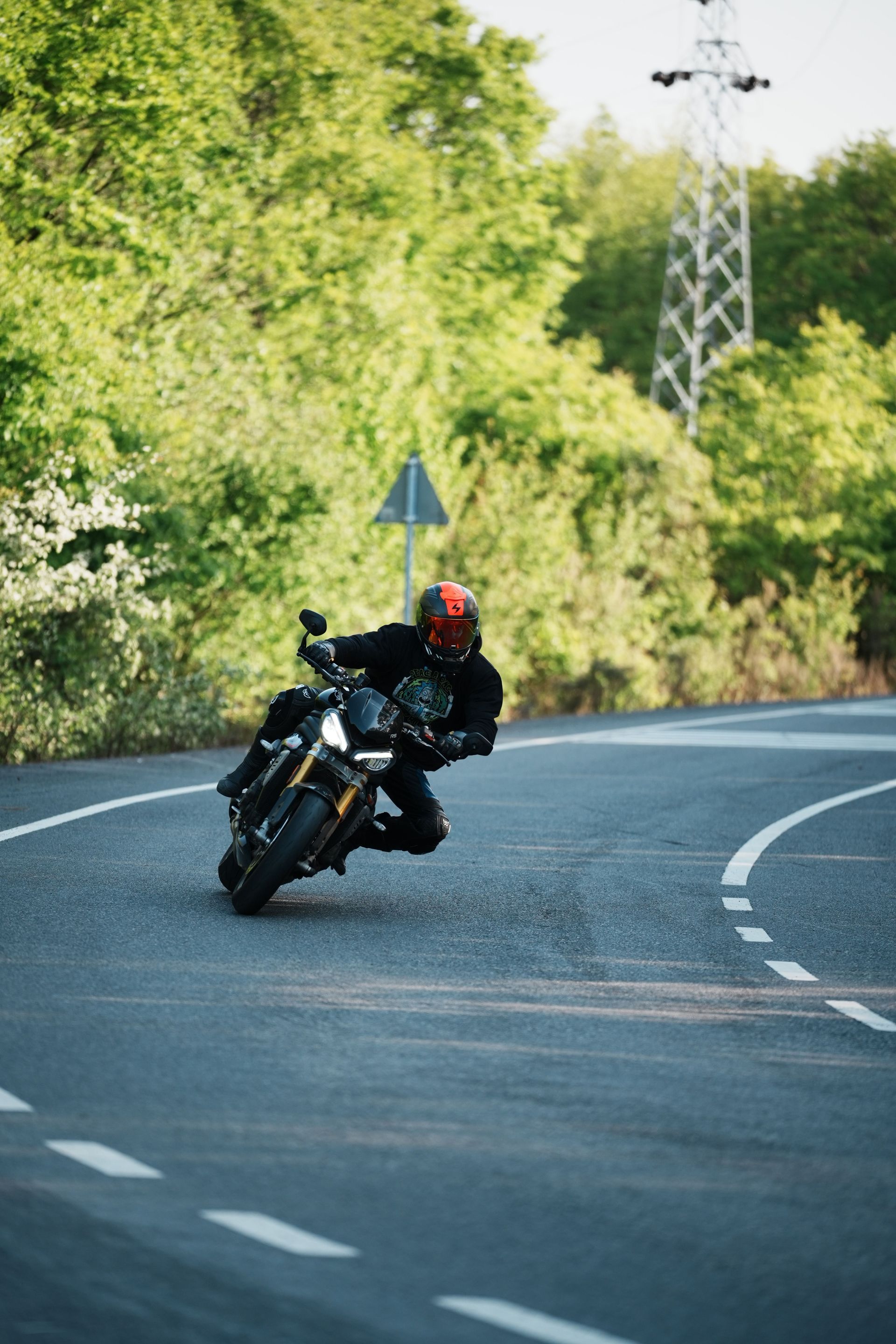 A motorcyclist rides around a corner on an empty street