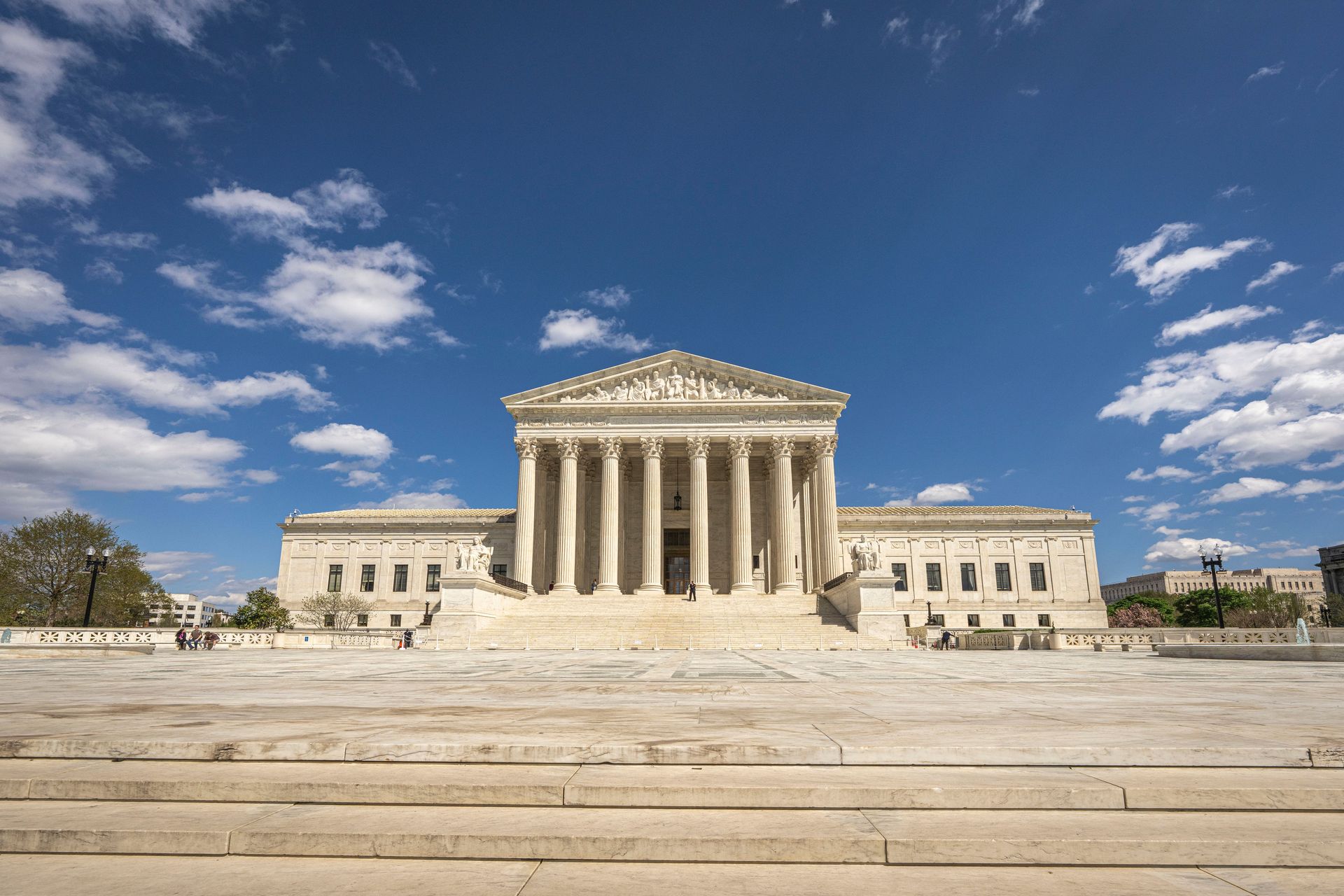 Wide shot of the Supreme Court with a blue sky in the background