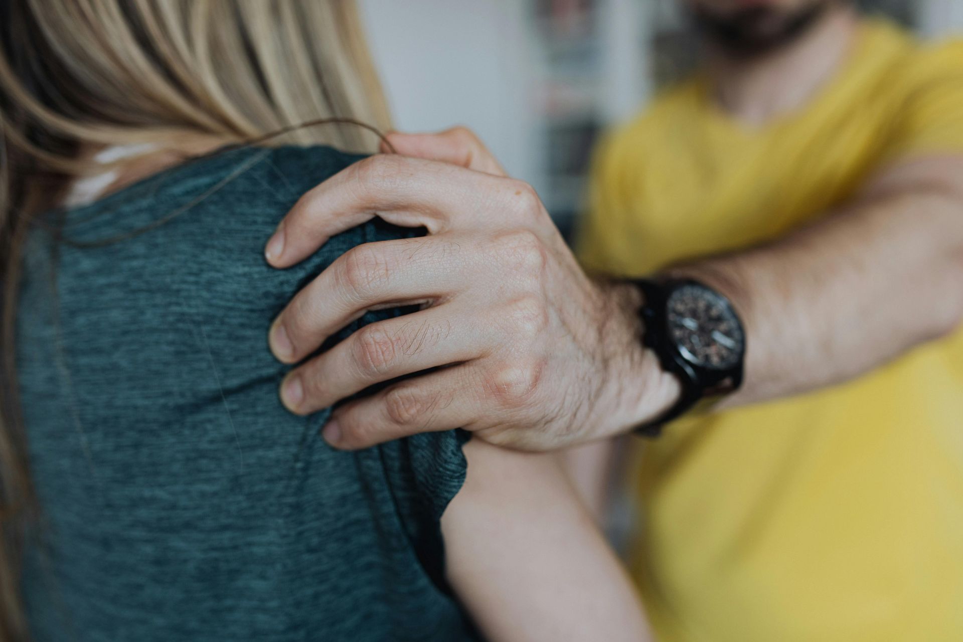 A unidentified man grabs an unidentified woman's shoulder