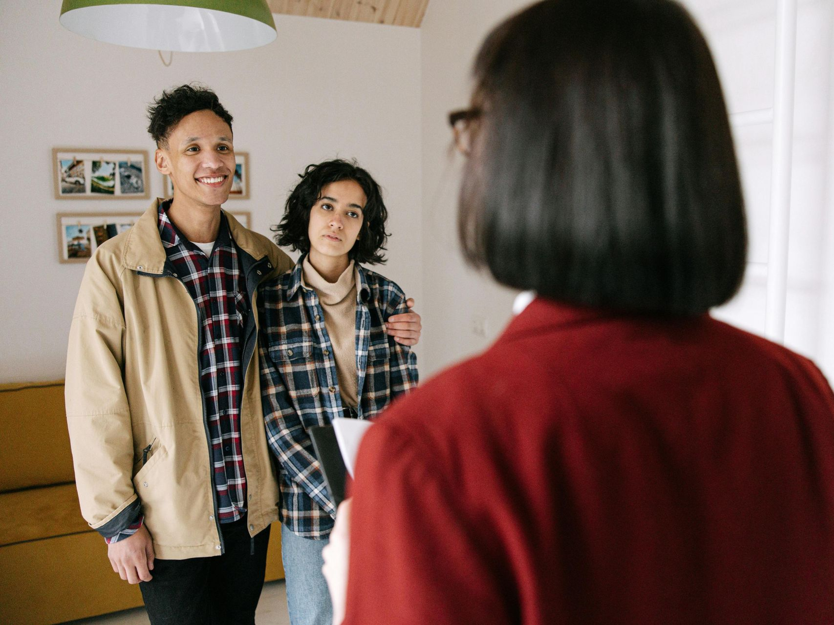 Couple with real estate agent indoors, looking at a home. Agent is holding paperwork. Landlord Tenant Disputes Law Attorney in Nashville, Tennessee