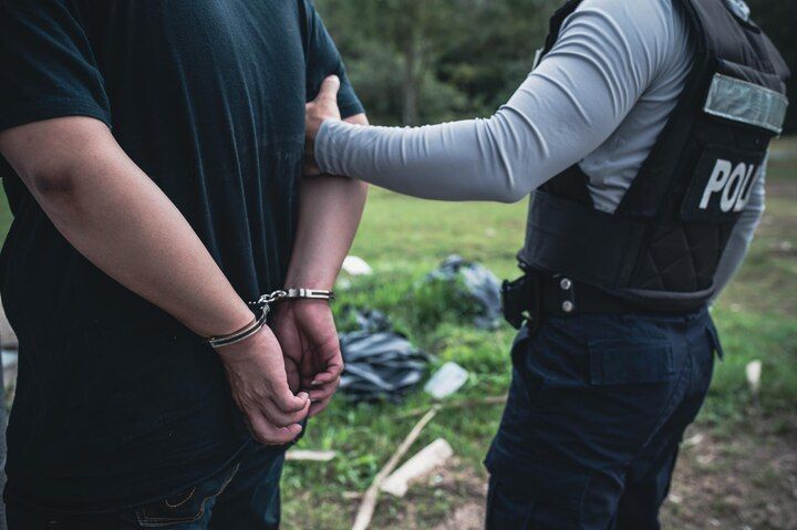 A person in handcuffs is held by a police officer. Voluntary Manslaughter Law Attorney in Nashville, Tennessee