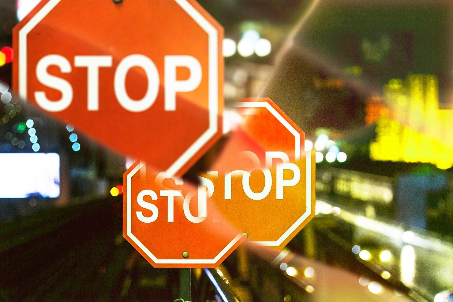 Multiple stop signs, blurred urban background. Traffic Violations / CDL Law Attorney in Nashville, Tennessee