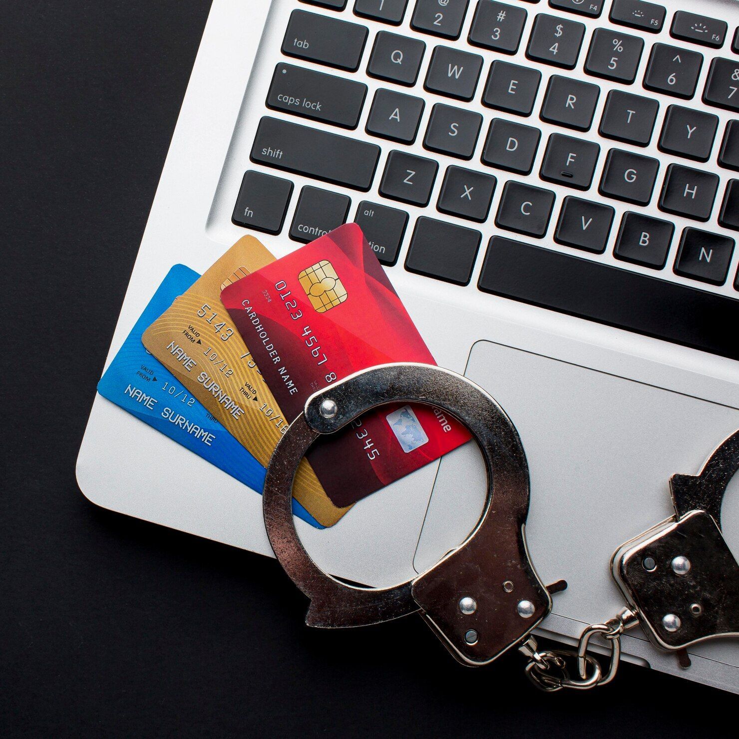 Credit cards and handcuffs on a laptop keyboard, representing financial crime. Credit / Debit Card Fraud Law Attorney in Nashville, Tennessee