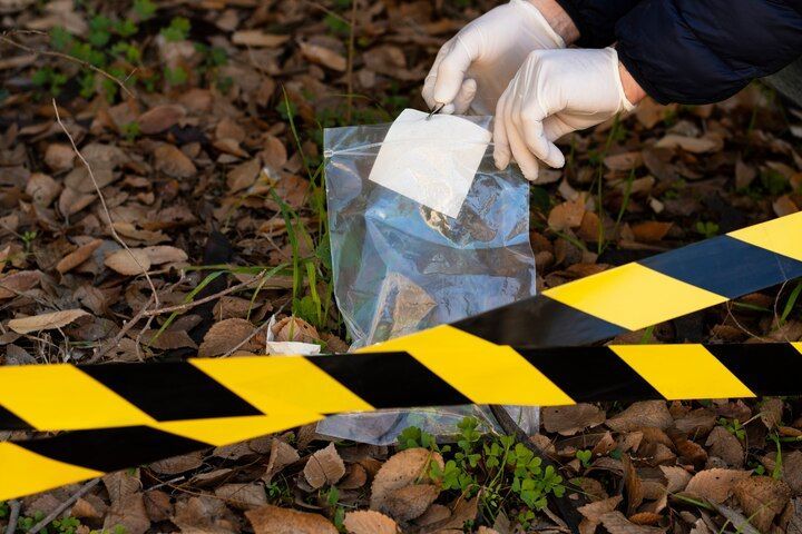 Person in gloves collecting evidence at a crime scene. Criminally Negligent Homicide Law Attorney in Nashville, Tennessee