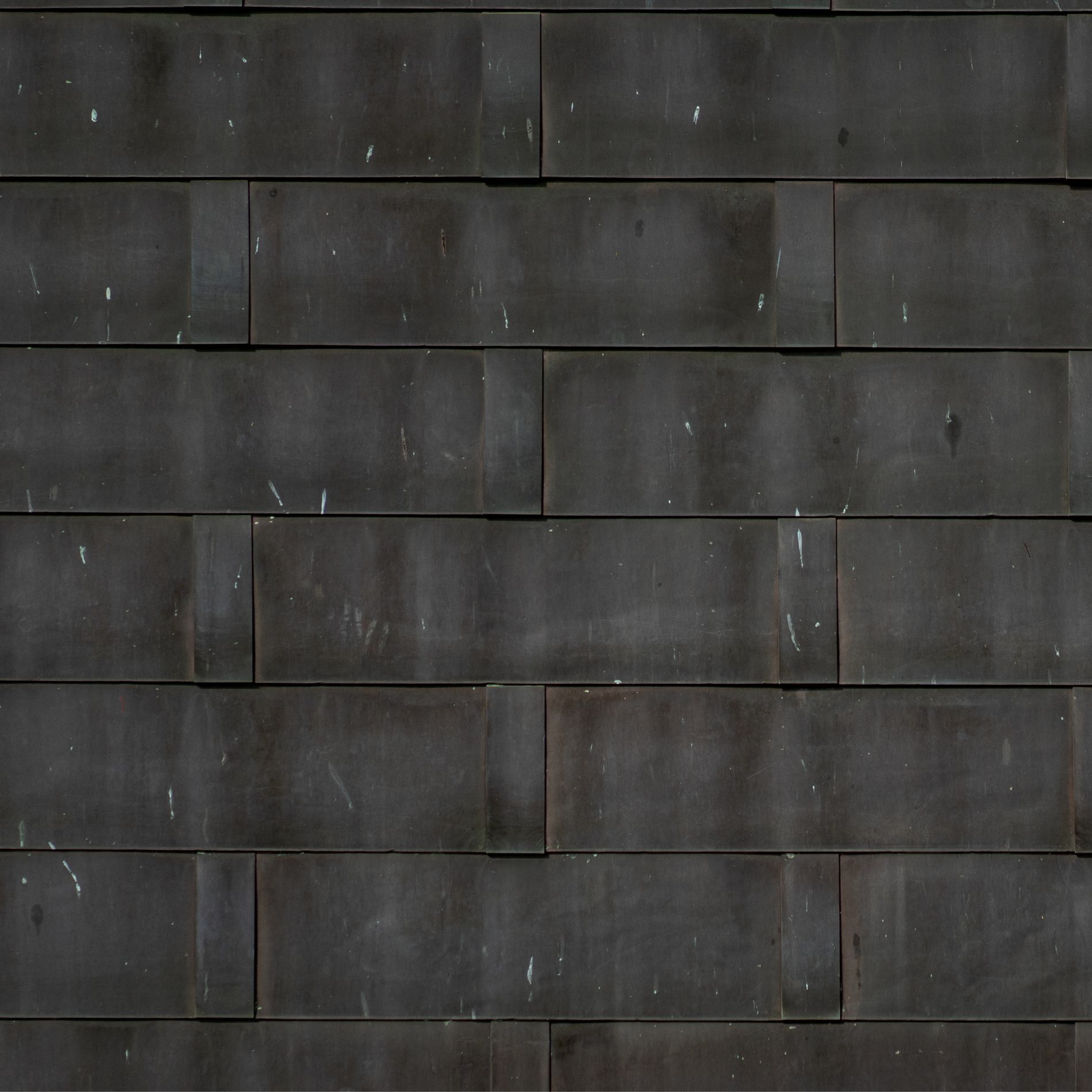 Dark gray brick wall with visible texture and white flecks.