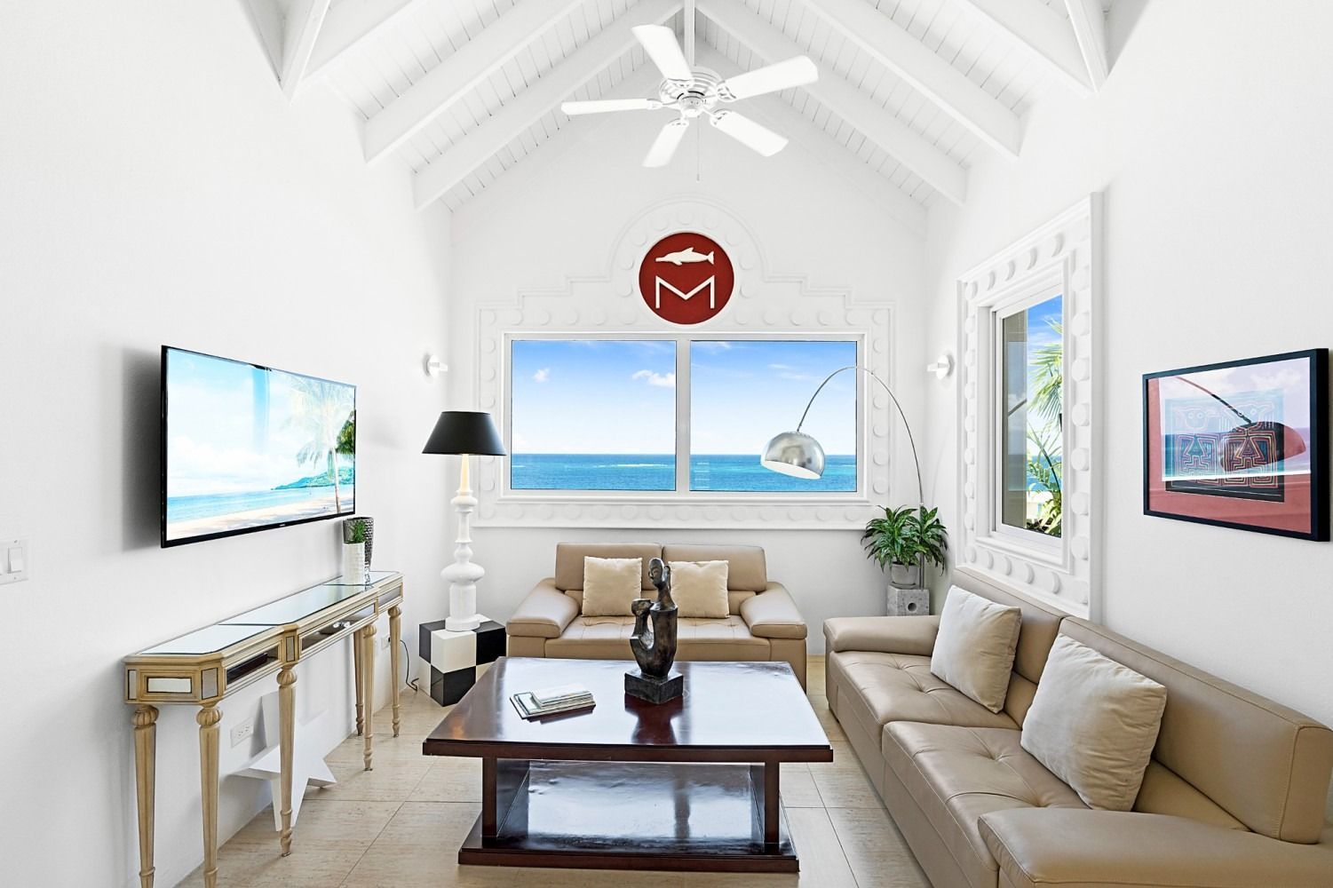 Bright living room with ocean view, two sofas, a coffee table, and TV.