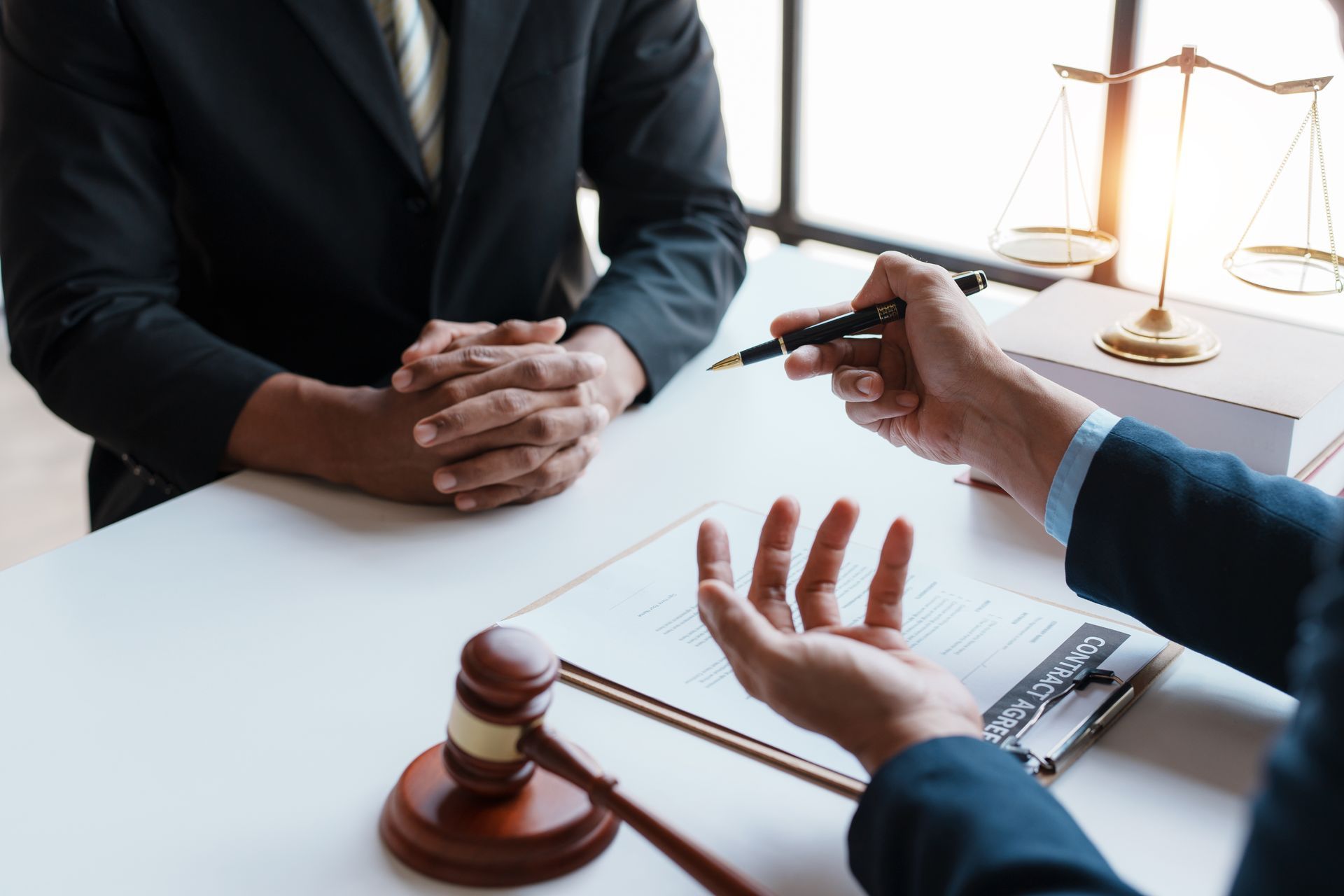 Lawyer meeting at desk with gavel, legal scales, and documents during consultation