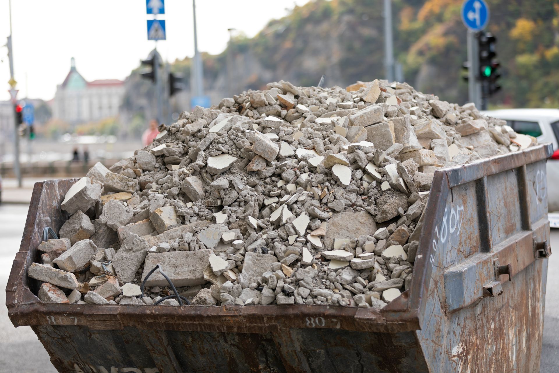 Dumpster filled with construction debris on a city street.