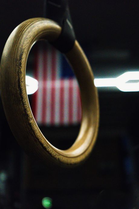 Gold ring hanging in front of a blurred red-and-white striped background with lights.