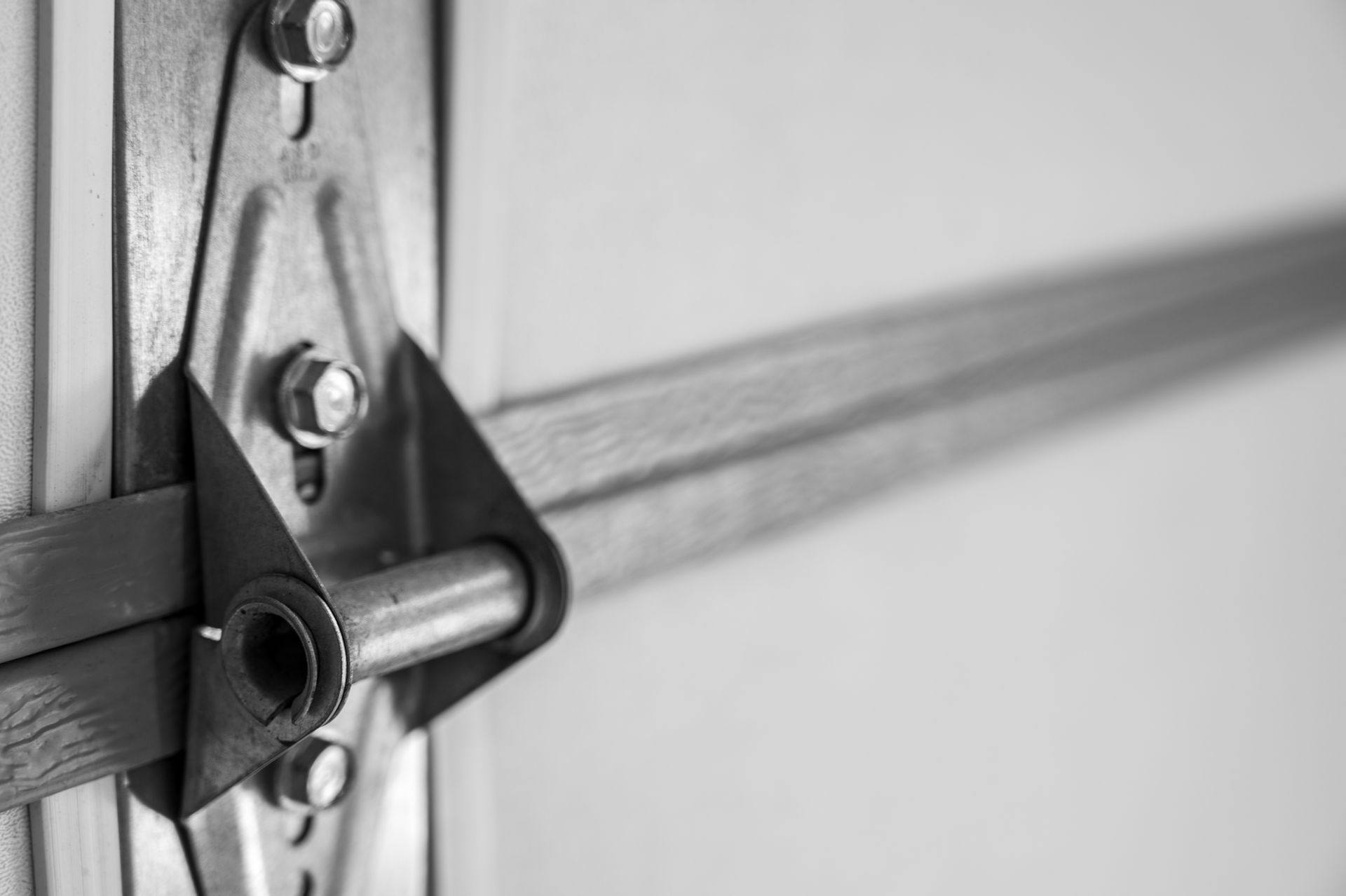 Close-up of a garage door hinge and handle in black and silver metal