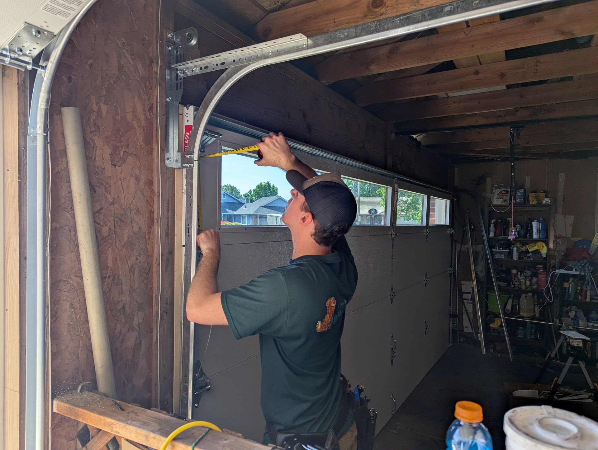 A man is working on installation of a garage door.