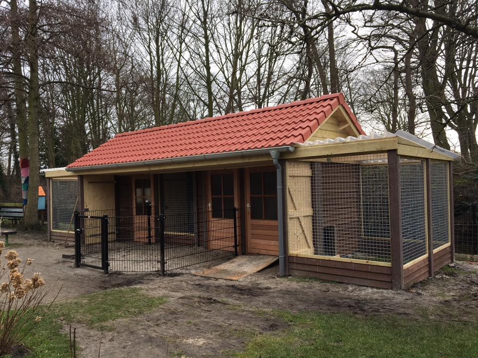 Dierenverblijf met rood pannendak en ruime buitenren, maatwerk van A&B Betonbouw.
