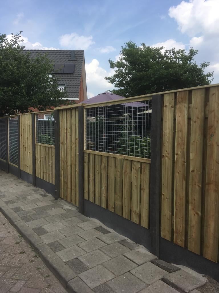 Combinatie van houten schutting met betonnen palen en gaaspanelen, geplaatst door A&B Betonbouw.