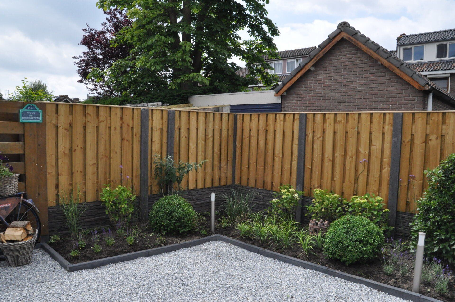 Houten tuinschutting met betonnen onderplaten, onderhoudsarme erfafscheiding van A&B Betonbouw.