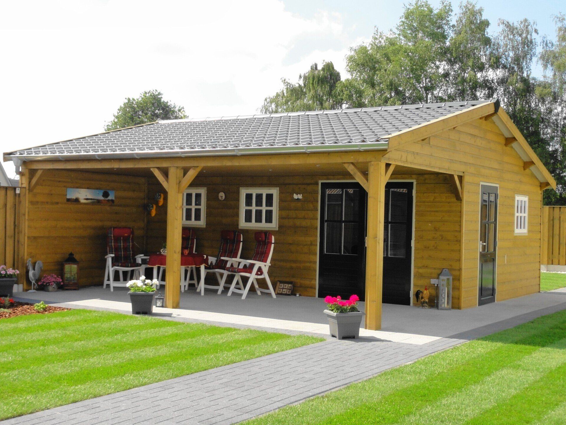 Tuinhuis met overkapping en houten gevelbekleding, tuinproject van A&B Betonbouw.