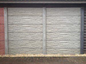 Betonschutting met grijs rotsmotief paneel, duurzaam en onderhoudsarm ontwerp van A&B Betonbouw.