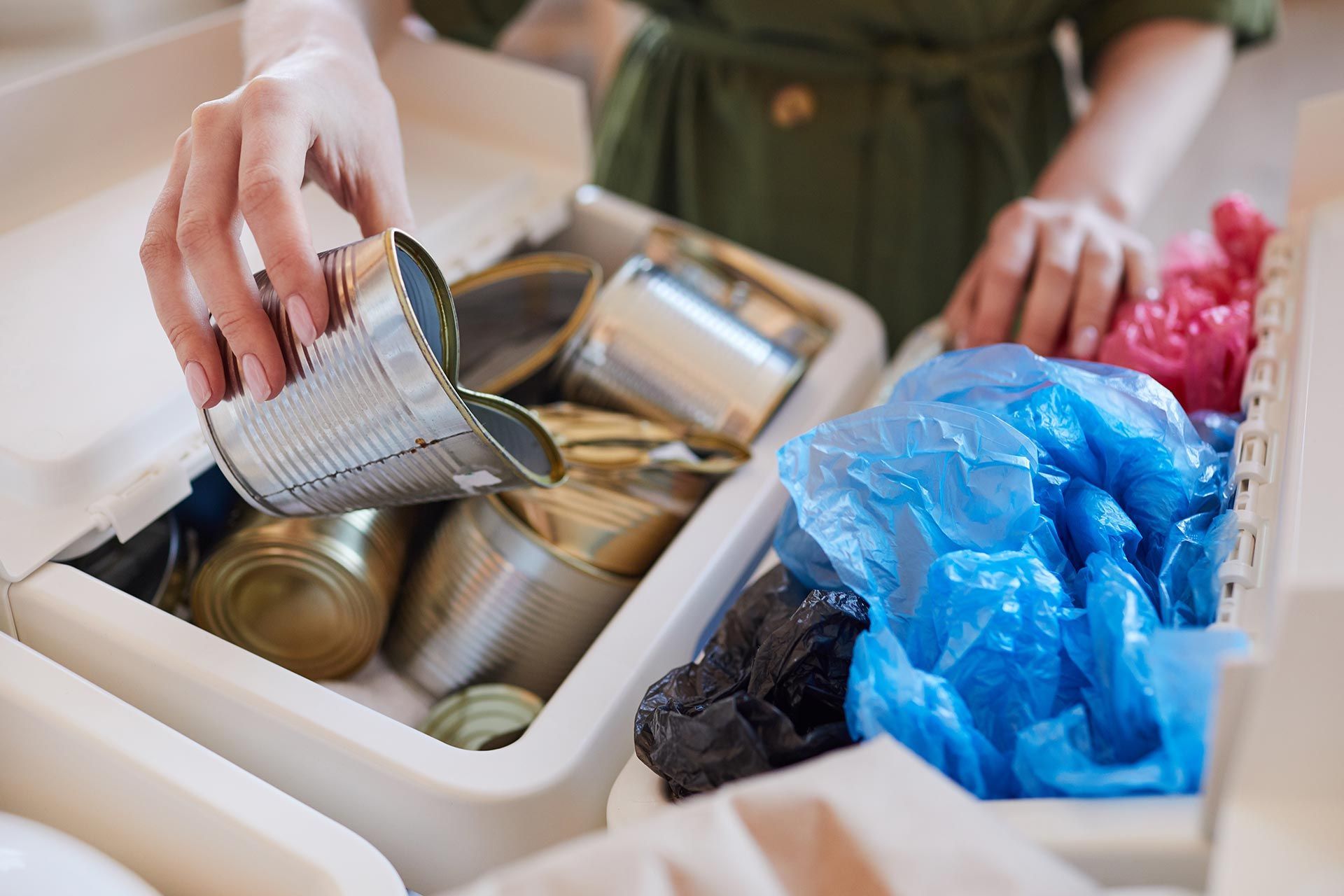Sorting aluminum cans for scrap recycling in a collection bin.