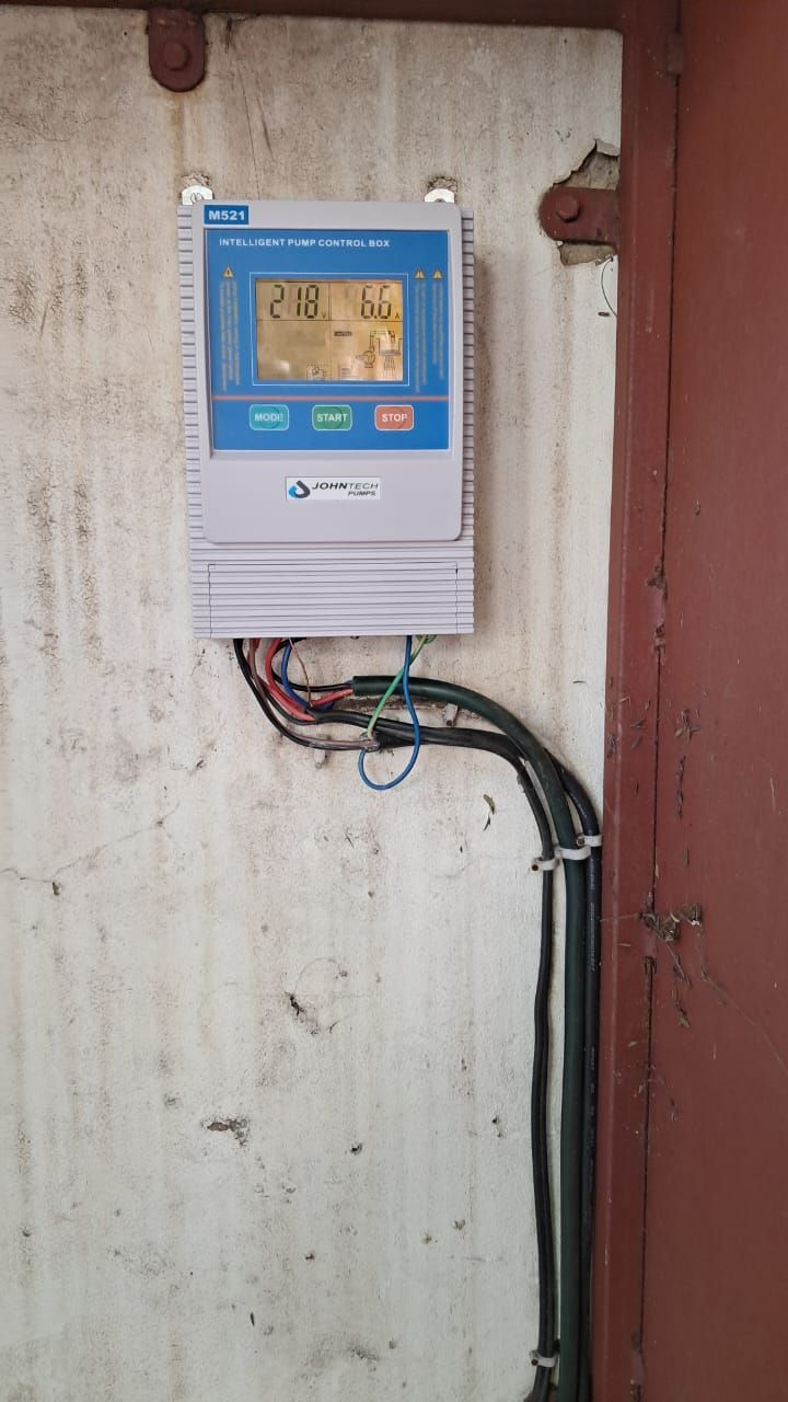 A control panel is hanging on a wall next to a door.
