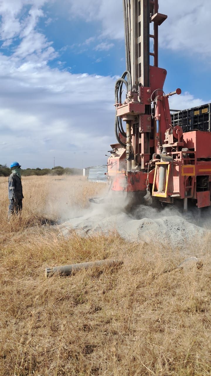 A man is standing next to a large machine in a field.