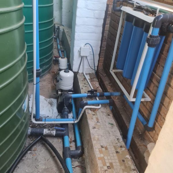 A bunch of blue pipes are connected to a wall