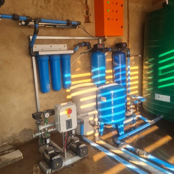 A room with blue pipes and a green tank