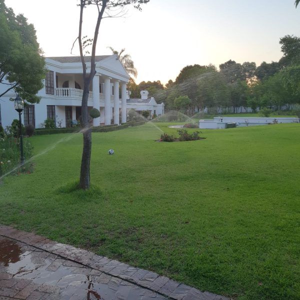 A large white house with a large lawn in front of it