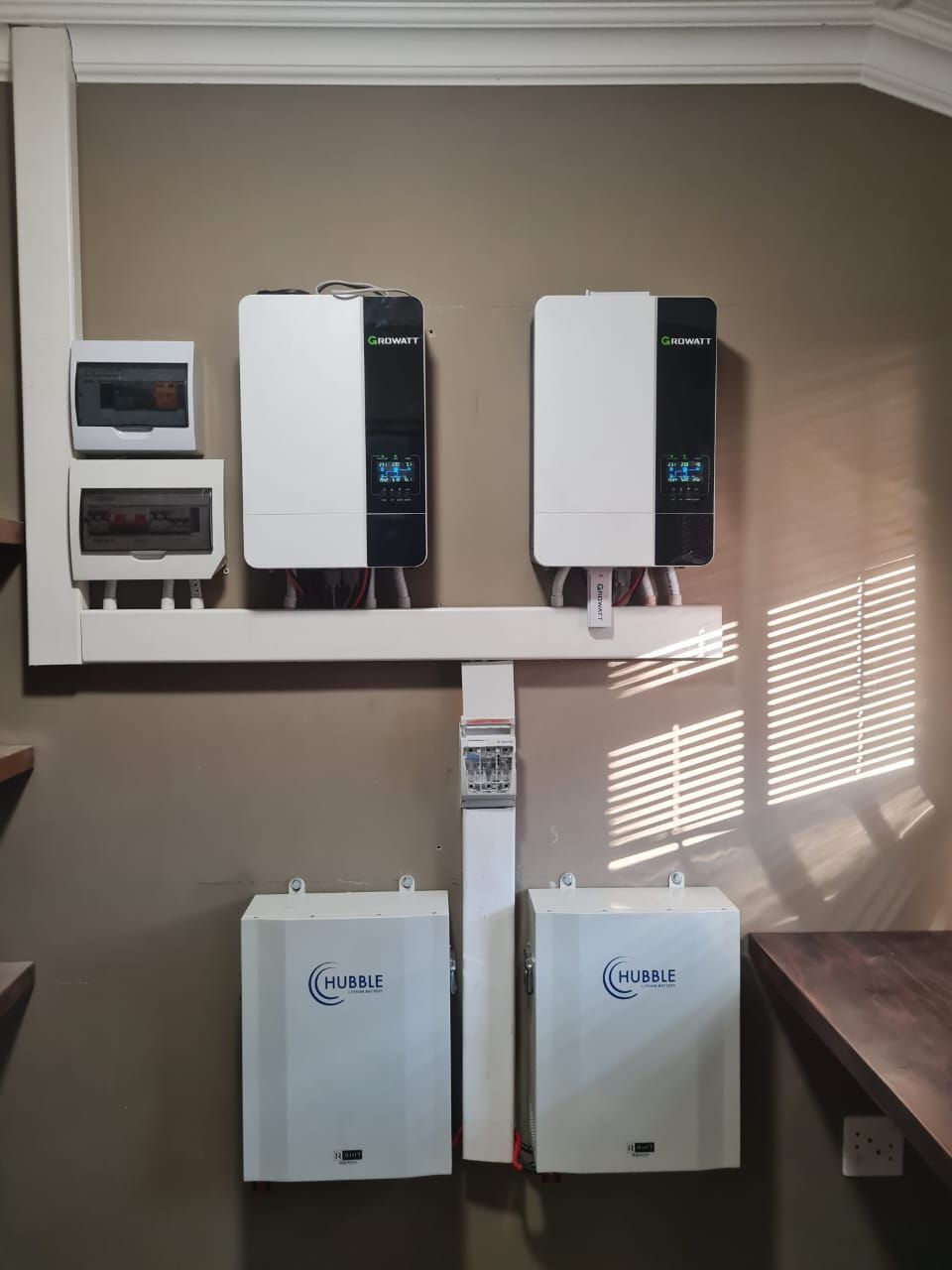 Two solar panels are mounted to the wall in a room