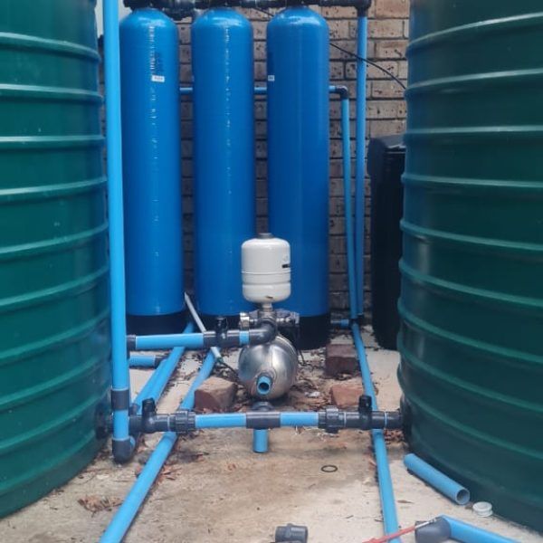A row of blue water tanks are lined up next to each other
