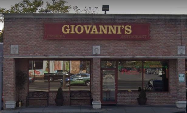 Giovanni's storefront with red sign on a brick building and large glass windows.