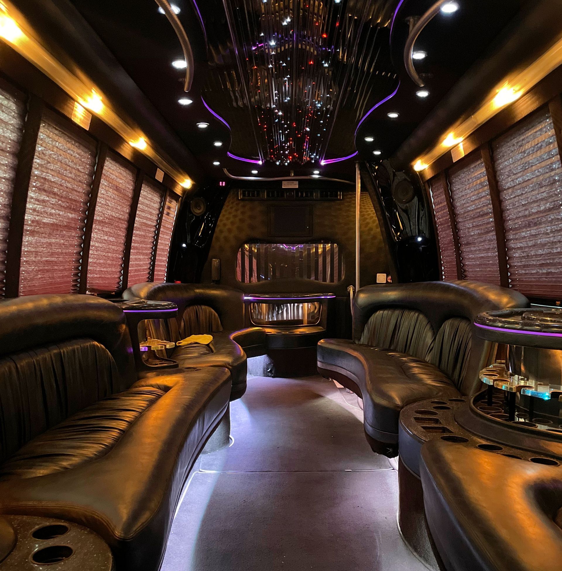 The inside of a limousine with purple lights on the ceiling