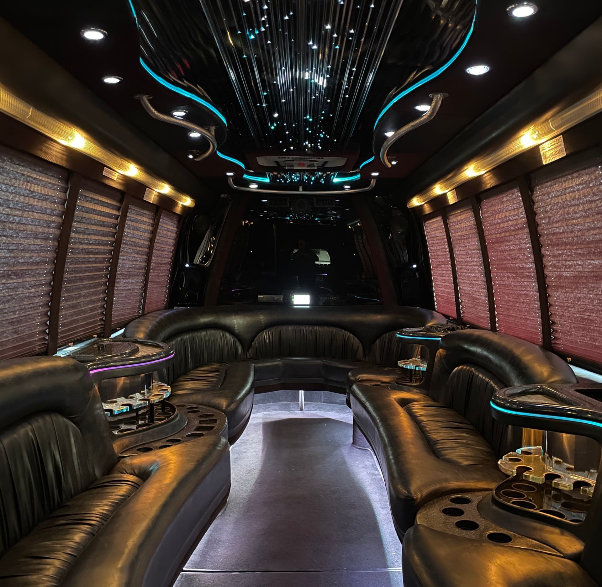 The inside of a limousine with lots of seats and tables
