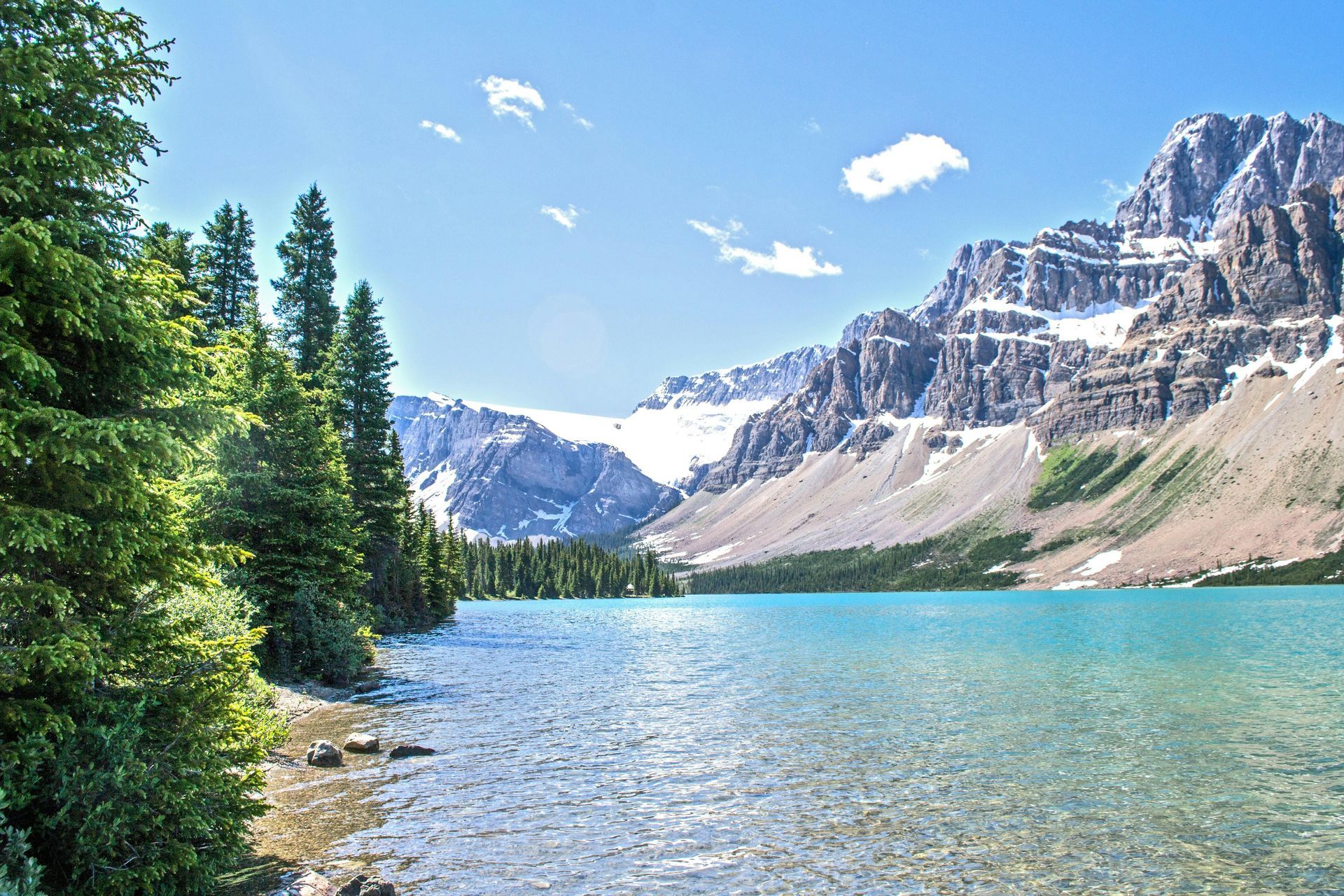 A lake with mountains in the background and trees on the shore