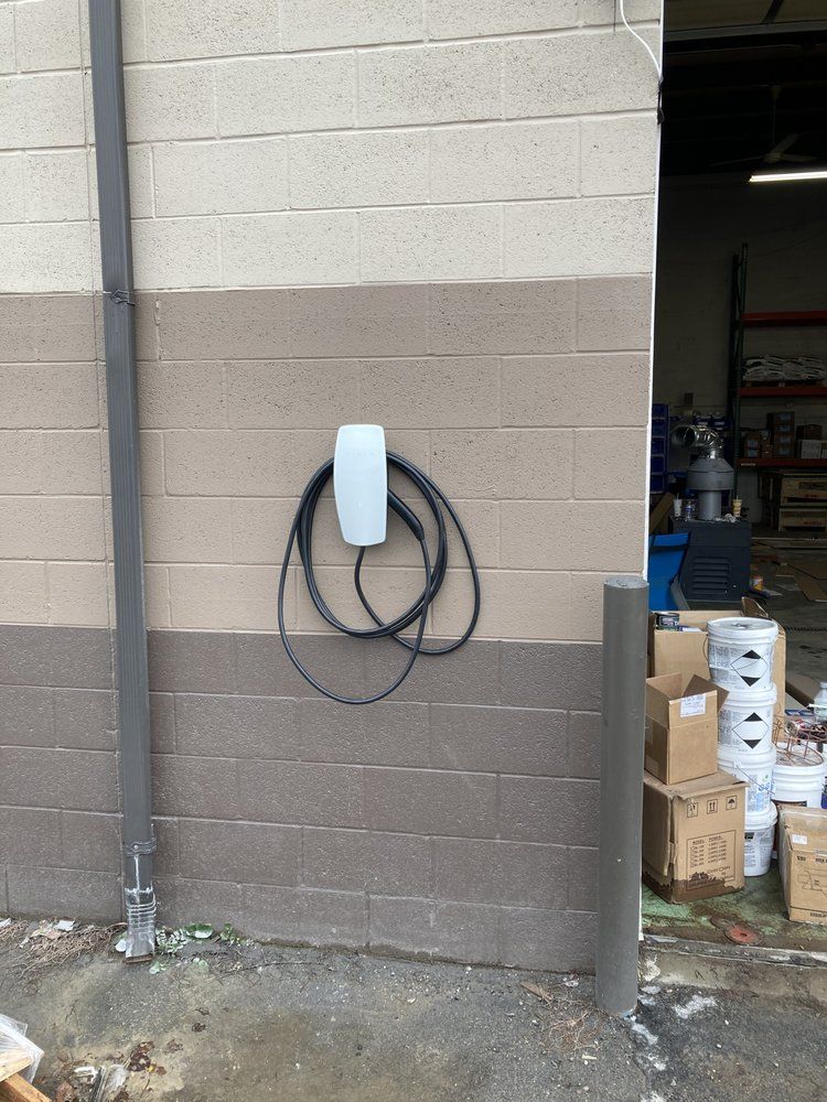 A brick wall with a electrical box attached to it.