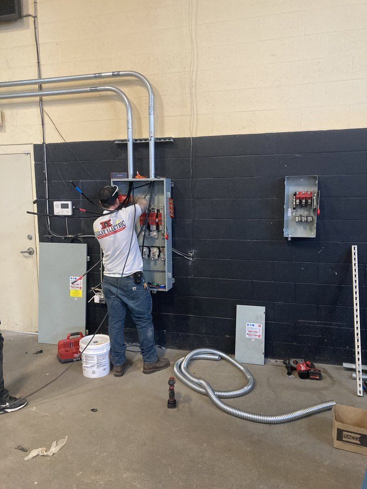 A man is working on a electrical box in a room.