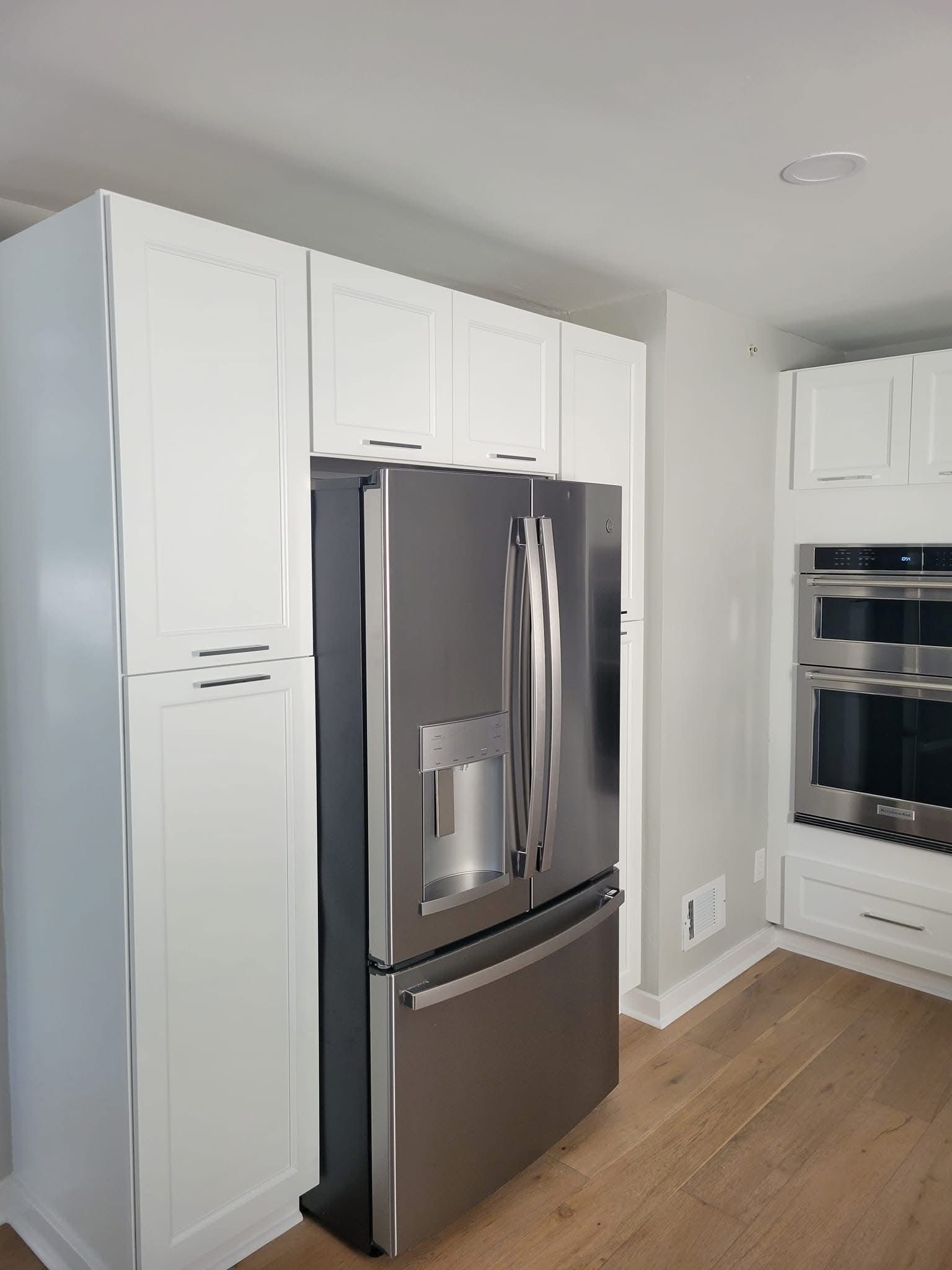 Modern kitchen with white cabinets and a stainless steel French-door refrigerator