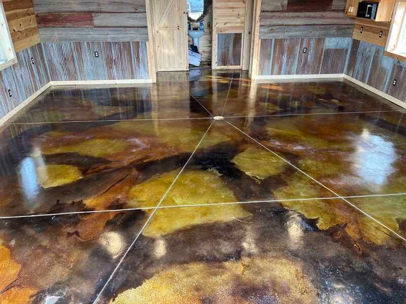 Glossy decorative epoxy floor with amber, black, and brown patterns in a wooden room