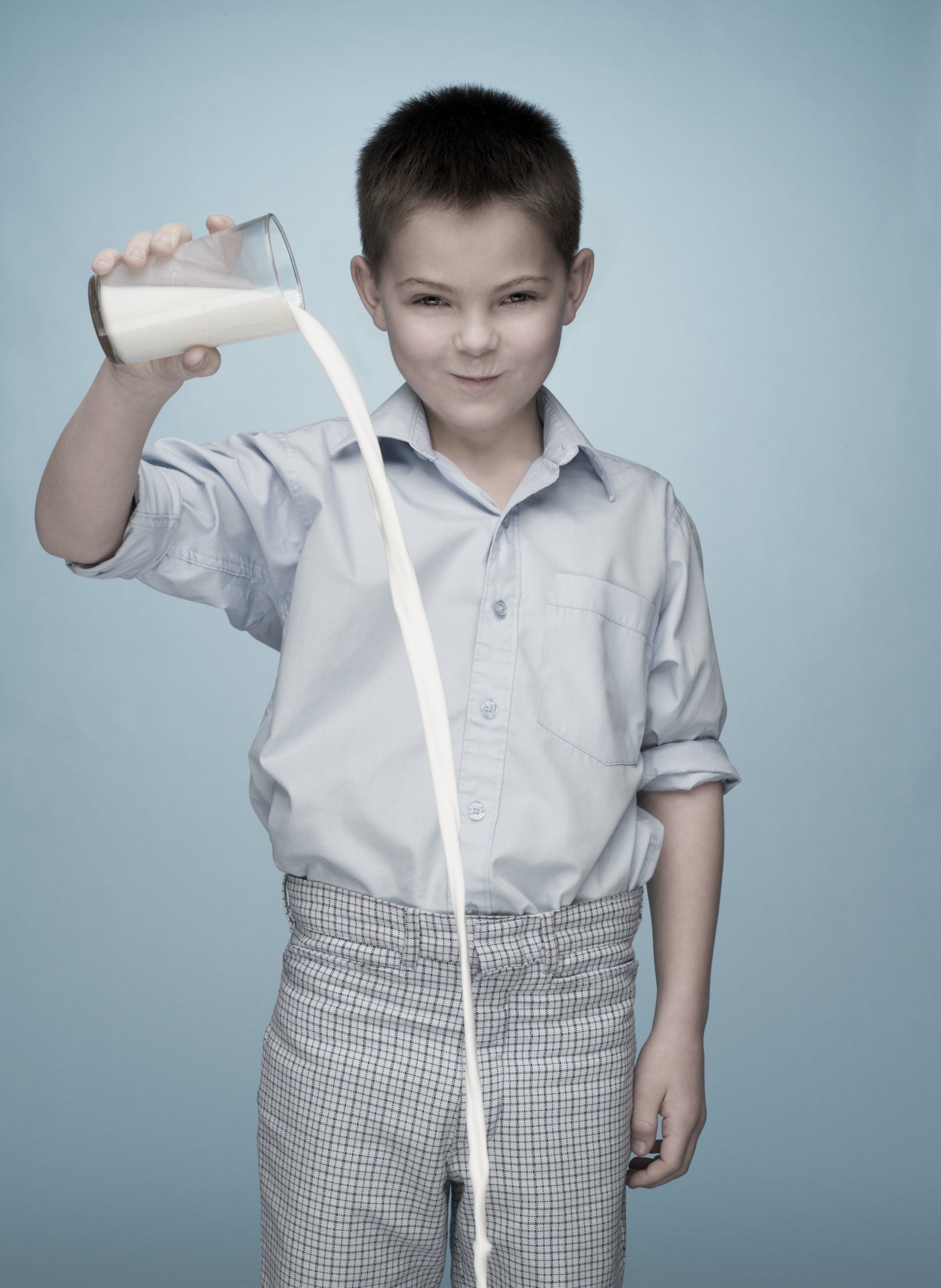 bambino versa del latte da un bicchiere