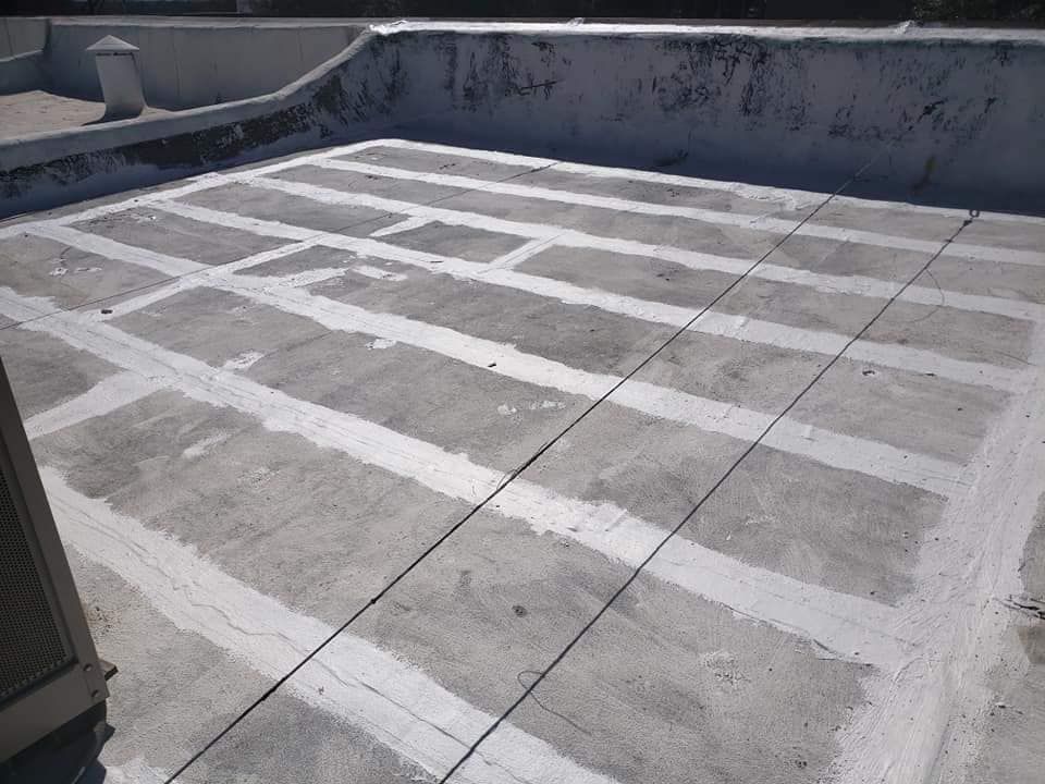 Rooftop concrete surface marked with white rectangular grid lines and surrounding low walls.