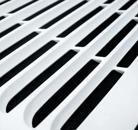 White slatted vent against a black mesh background.