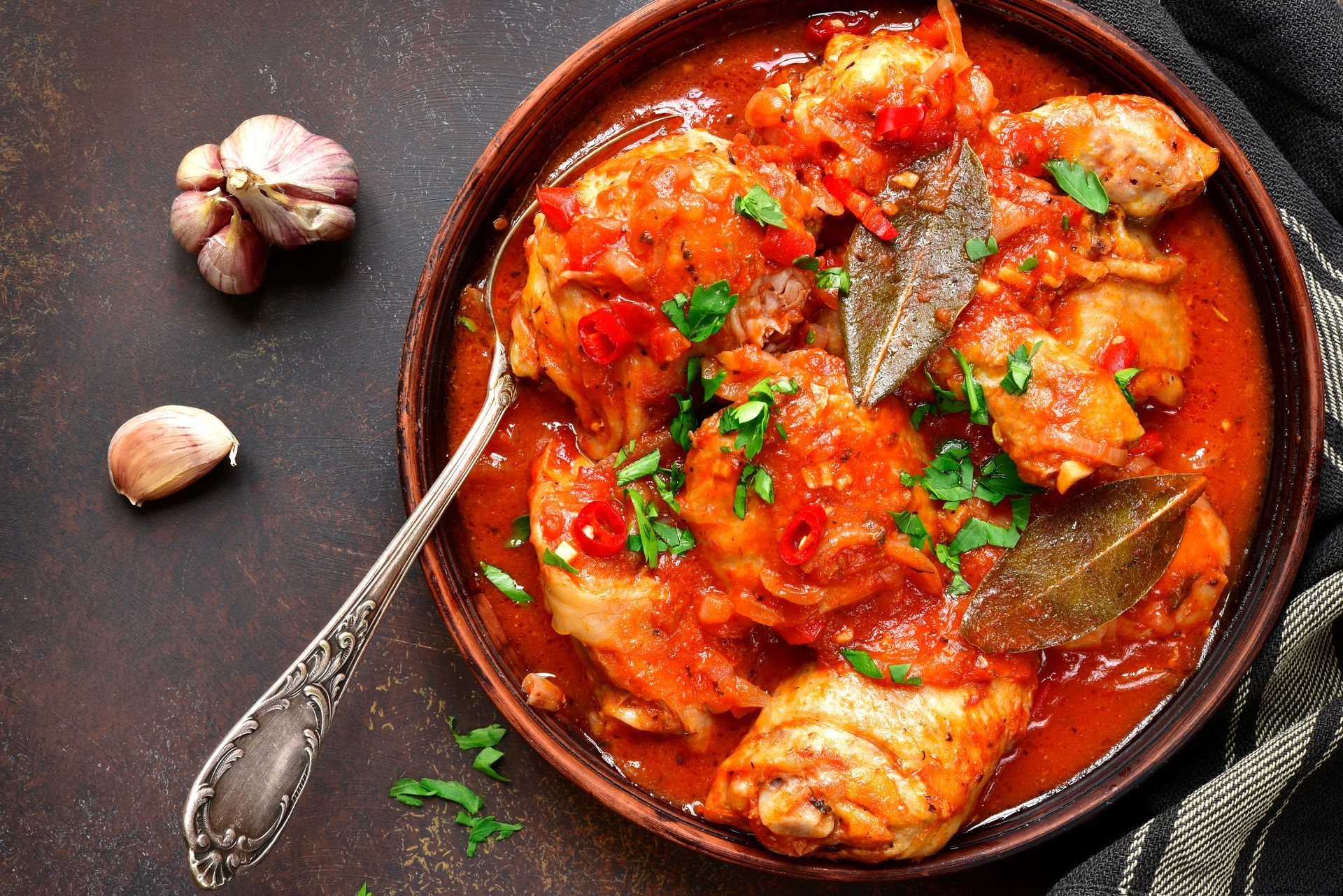Dark glossy stew chicken in cast-iron pot