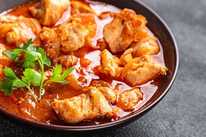 Stew chicken simmering in dark gravy
